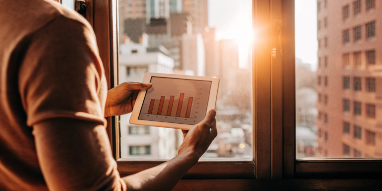 Small business owner reviews finances on a tablet.