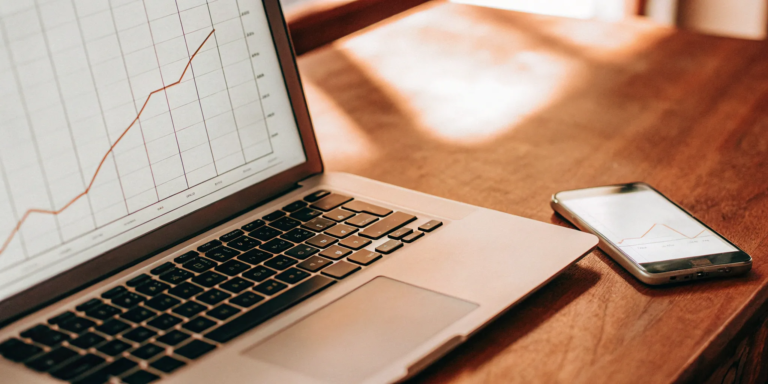 A laptop showing positive financial charts for a merchant cash advance with same day funding.