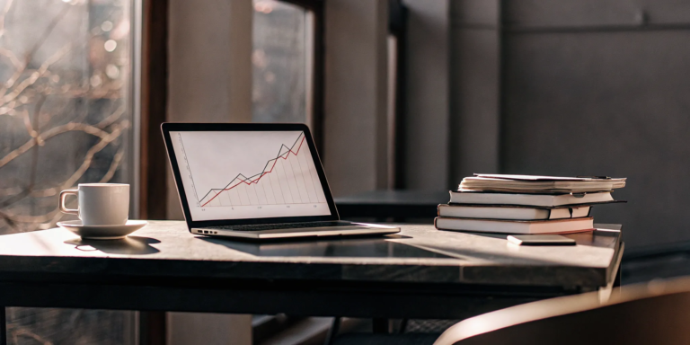 How to manage small business cash flow shown on a laptop with a financial chart.