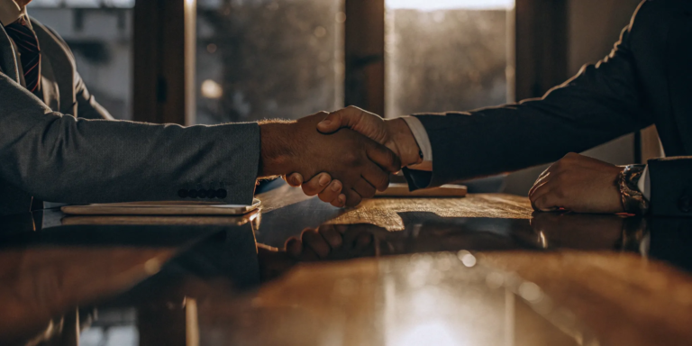 Business owner shaking hands after securing a deal with a top merchant cash advance company.