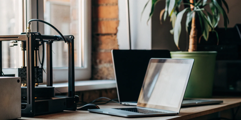 Modern office equipment, like a laptop and 3D printer, funded by a top equipment financing lender.
