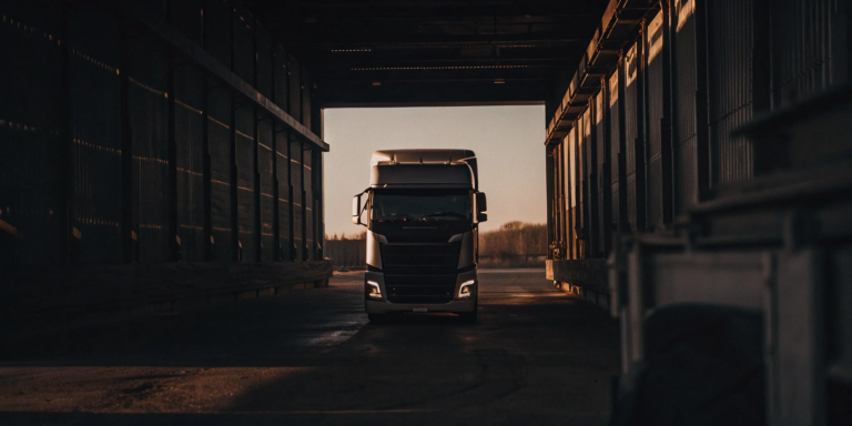 A semi truck at a loading dock, a familiar sight for businesses using invoice factoring for trucking companies.