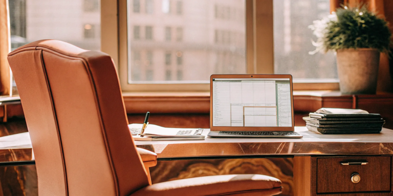 Desk with laptop and paperwork for a business owner learning how to get equipment financing.