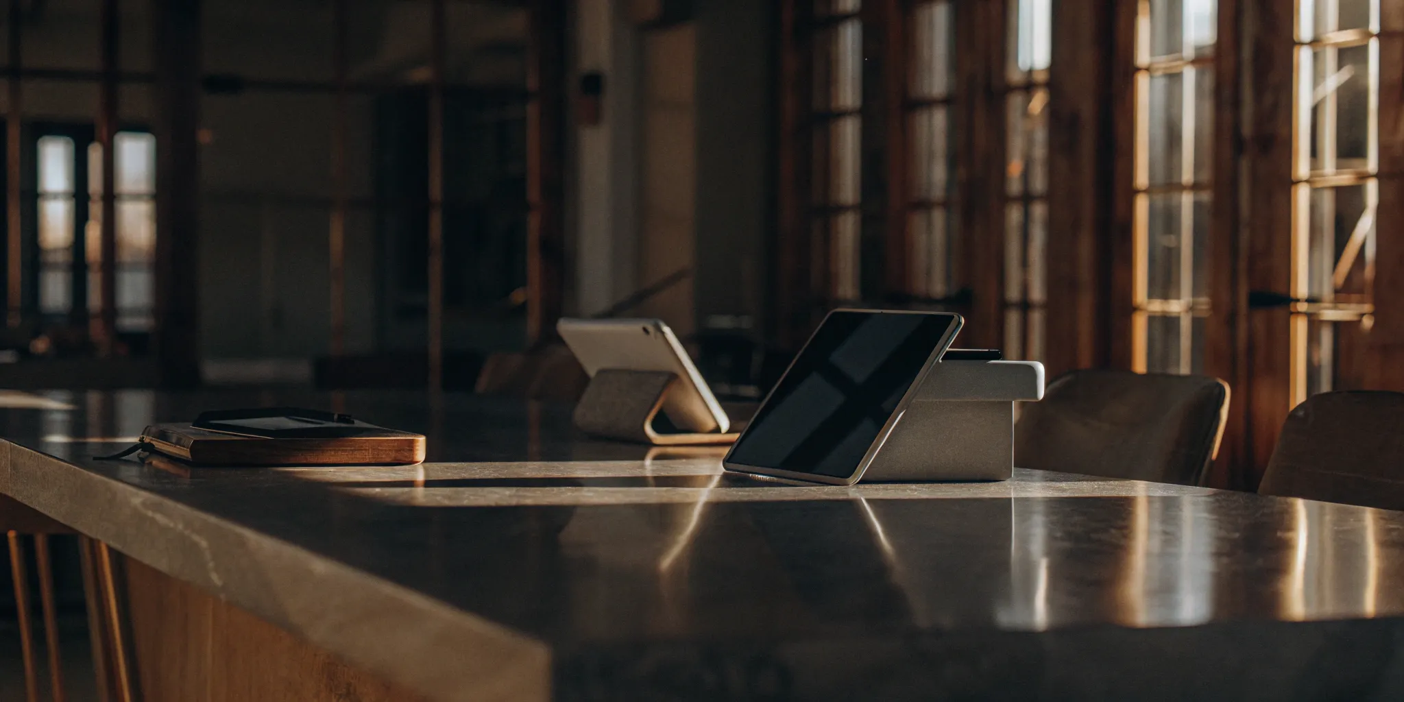 Comparing the best commercial equipment lenders on tablets at an office conference table.