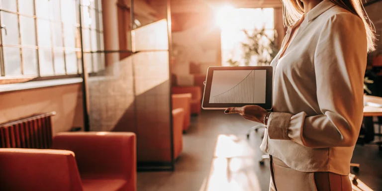 Business Sales Finance: How It Works for SMBs 1 Businesswoman reviews a rising sales graph on a tablet, a key metric for sales-based financing.