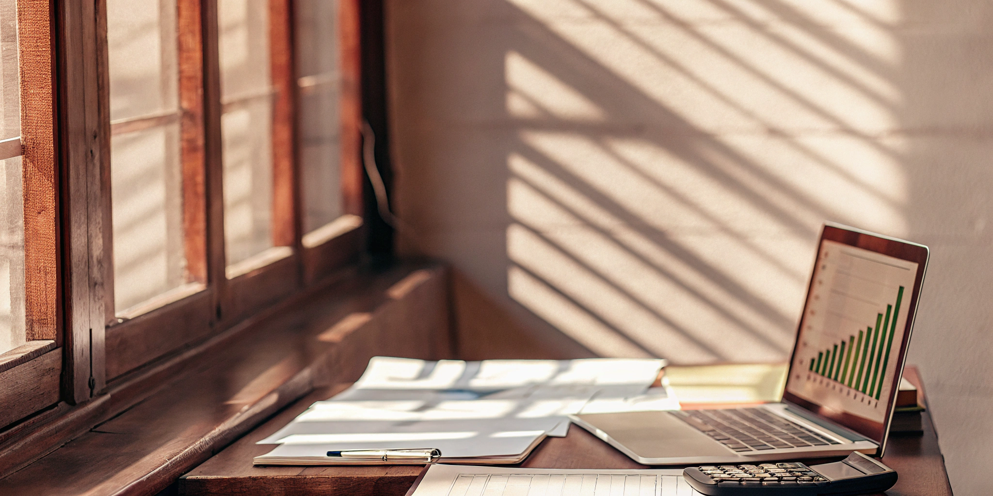 Laptop, calculator, and documents used for planning the financing of large customer orders.